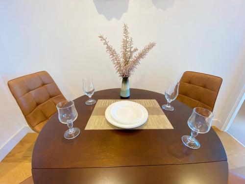 a dining room table with a plate and wine glasses at Cozy 2B2B Apartment with Free Parking & Penthouse Pool in Box Hill