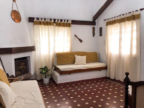 - un salon avec un canapé et une cheminée dans l'établissement Villa Vazquez - Chalet con Quincho, à La Falda