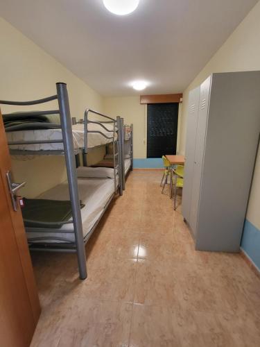 a room with bunk beds and a table and a chalkboard at COMPLEXO TURISTICO PONTE MOURULLE in Insúa