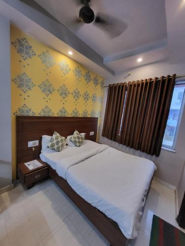 a bedroom with a bed and a yellow wall at Hotel Atithi Residency in Lucknow