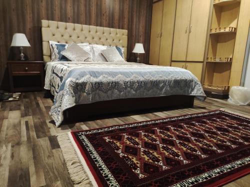 a bedroom with a bed and a rug on the floor at Holiday home On The rocks in Murree