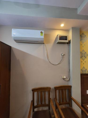 a room with two chairs and a air conditioner on the wall at Hotel Atithi Residency in Lucknow