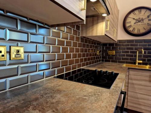 a kitchen with a stove and a clock on the wall at The Duke in Preston