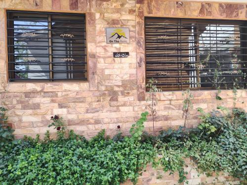 a brick wall with two windows and plants at Holiday home On The rocks in Murree