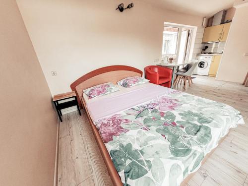 a bedroom with a bed with a floral comforter at Lampedziai Apartment in Kaunas