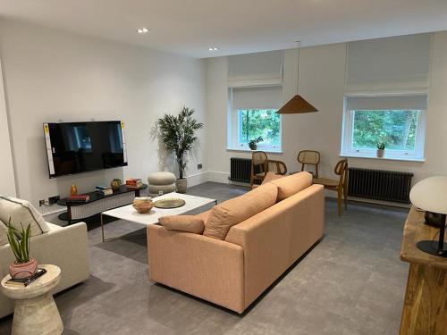 a living room with a couch and a tv at Gorgeous newly refurbished 2 bedroom apartment in London in London