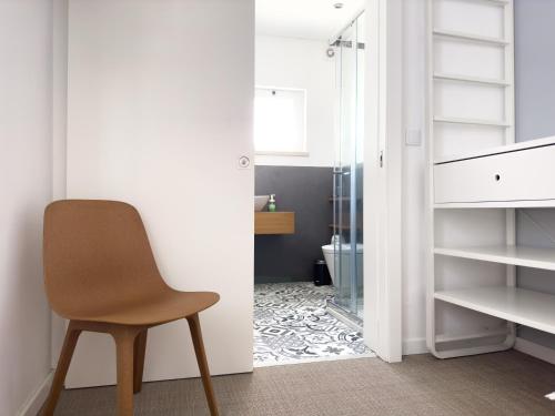 a chair sitting in a bathroom with a closet at Solar do Alentejo in Cercal