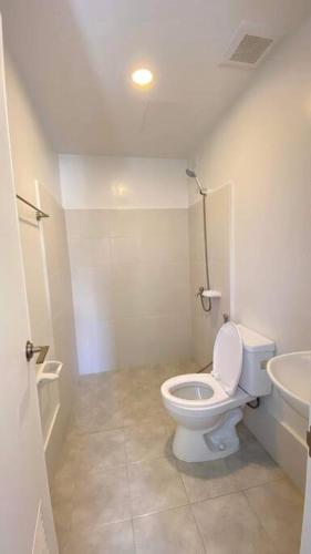 een witte badkamer met een toilet en een wastafel bij Platform 361 in Cebu City