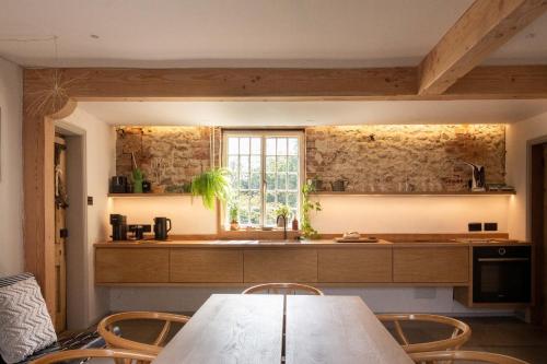 een keuken met een tafel en stoelen en een raam bij Relax, unwind and enjoy village life.... in Castle Acre