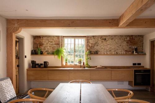 uma cozinha com mesa e cadeiras e uma janela em Relax, unwind and enjoy village life.... em Castle Acre
