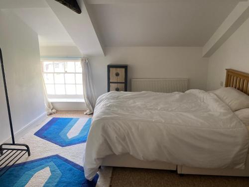a bedroom with a white bed and a window at Royal Oak Apartment 1 in Cerne Abbas