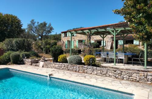 a house with a swimming pool in front of a house at Lou Peiraverde in Mons