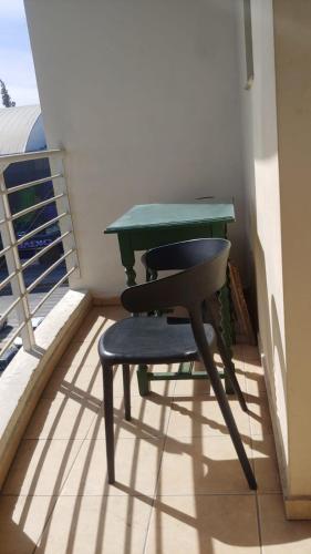 a green table and a chair on a balcony at Tulùm in San Juan