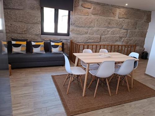 einen Tisch und Stühle im Wohnzimmer mit Sofa in der Unterkunft Casa Nova de Senradelas in Marco de Canavezes