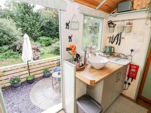 un baño en una casa pequeña con lavabo y ventana en Cobblers Cabin, en Northampton