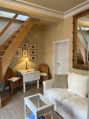 a living room with a white couch and a table at Le 25, Duplex élégant au cœur du piétonnier historique in Namur