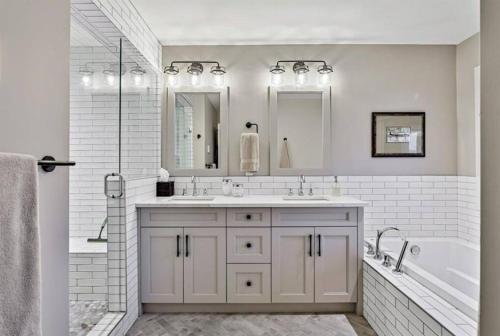 biała łazienka z wanną, umywalką i prysznicem w obiekcie Canmore Chalet with Hot tub at Three Sisters Mtn w mieście Canmore