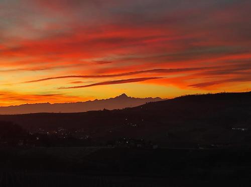 a sunset with a mountain in the background at Agriturismo Bianconiglio in Monforte dʼAlba
