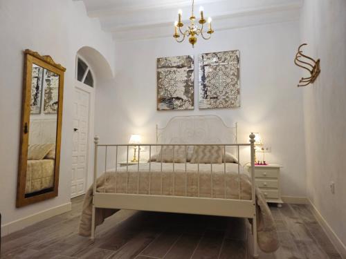 - une chambre avec un lit blanc et un lustre dans l'établissement Apartamento Casa Pura, à Medina-Sidonia