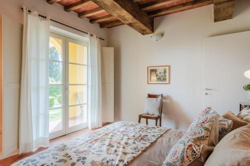 a bedroom with a bed and a window at Casa Lucchese al Borghetto in Collodi