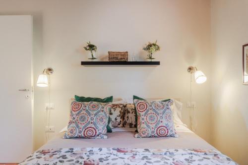 a bedroom with a bed with pillows and two lights at Casa Lucchese al Borghetto in Collodi