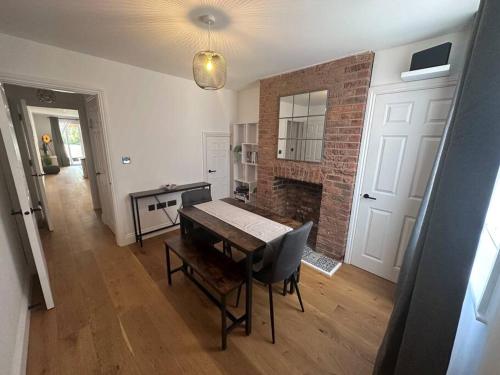 a living room with a table and a brick wall at Riverside 3 Bed House in Winchester