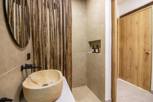 a bathroom with a shower with a stone tub at Hotel Boutique de playa - Casa Solhu in Santa Marta