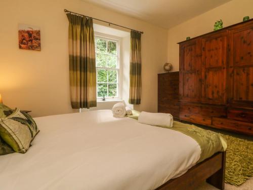 a bedroom with a large white bed and a window at Gweek House in Helston