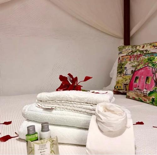uma pilha de toalhas numa cama num quarto em Cantinho da Cineka em Caraíva