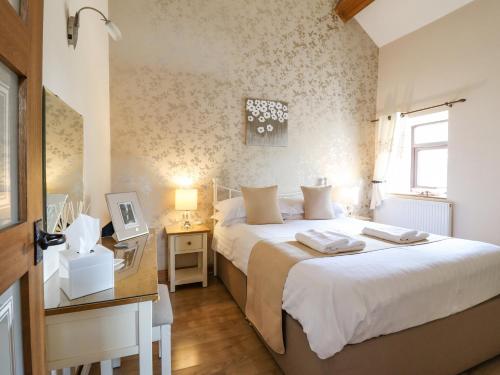 een slaapkamer met een bed, een bureau en een raam bij Bwthyn Ty Newydd in Pont Dolanog