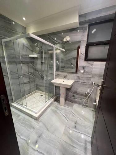 La salle de bains est pourvue d'une douche et d'un lavabo. dans l'établissement دوبلكس بيفرلي هيلز اربع غرف الشيخ زايد فرش مودرن, à Sheikh Zayed