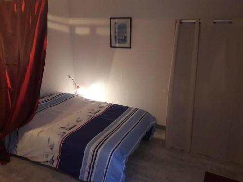 - une chambre avec un lit doté d'une couverture rouge et bleue dans l'établissement Charmant Studio Meublé (en plein centre de Dieppe), à Dieppe
