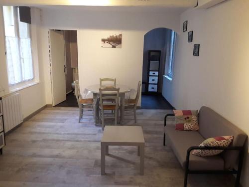 un salon avec un canapé et une table dans l'établissement Charmant Studio Meublé (en plein centre de Dieppe), à Dieppe