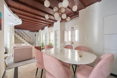 a dining room with a white table and pink chairs at My Lisbon Home Castelo in Lisbon
