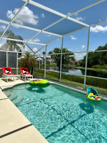 a swimming pool with two inflatables in the water at Private pool with a beautiful view overlooking the lake! Near Disney - Universal in Kissimmee