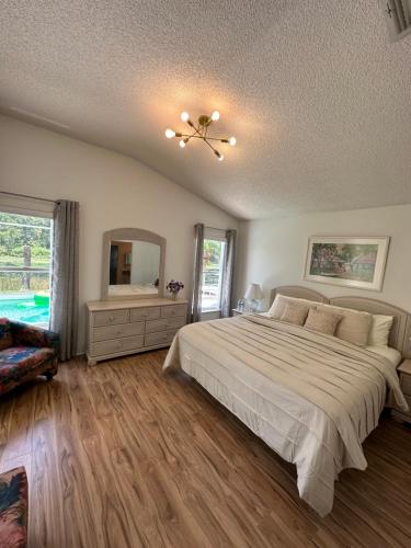 a bedroom with a large bed and a mirror at Private pool with a beautiful view overlooking the lake! Near Disney - Universal in Kissimmee