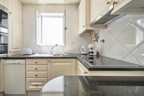 a kitchen with a sink and a window at My Lisbon Home Castelo in Lisbon