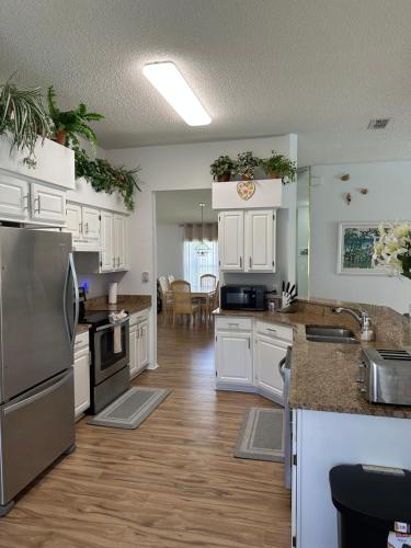 a kitchen with white cabinets and stainless steel appliances at Private pool with a beautiful view overlooking the lake! Near Disney - Universal in Kissimmee