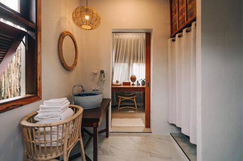 a bathroom with a tub and a sink and a mirror at Rest Sea Resort Koh Kood in Ko Kood