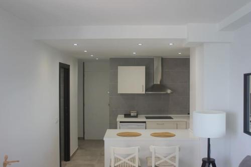 - une cuisine avec un comptoir blanc et une cuisinière dans l'établissement Apartamento primera línea de mar, à Platja d'Aro