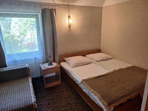 Brīviņi في Jaunjelgava: غرفة نوم صغيرة بها سرير ونافذة