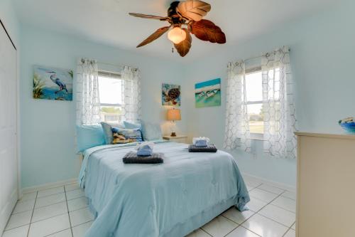 um quarto com uma cama azul e uma ventoinha de tecto em Pet-Friendly Port Charlotte Home with Canal Access! em Port Charlotte