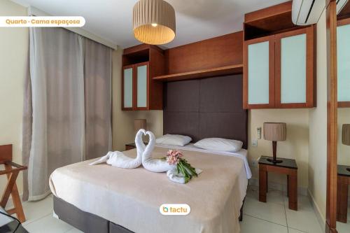 - une chambre avec deux cygnes assises sur un lit dans l'établissement Studio charmant au VG face à la piscine, à Paracumbuca