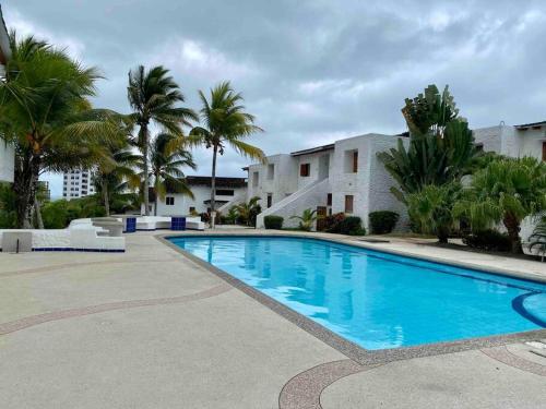 uma piscina com palmeiras e um edifício em Casa Blanca - Altos del Mar em Same
