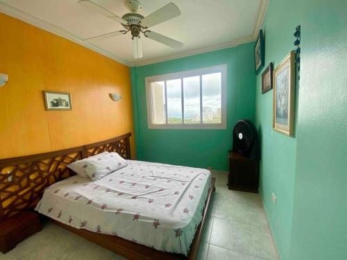 um quarto com uma cama com paredes em verde e laranja em Casa Blanca - Altos del Mar em Same