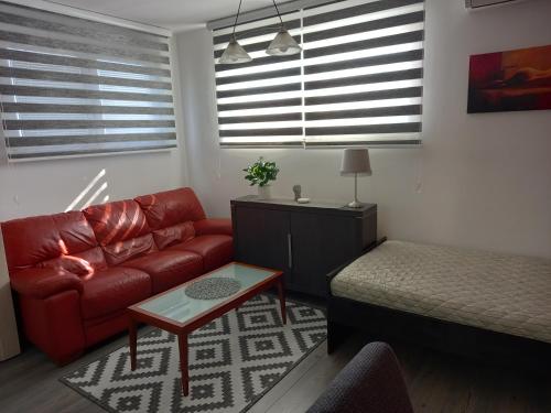 a living room with a red couch and a table at Kuća za odmor sa 3 spavaće sobe in Kragujevac