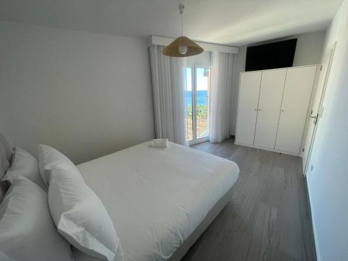 a white bedroom with a large bed and a window at Tides proprety - Medium Tide in Paul do Mar