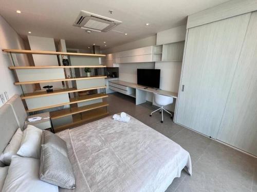 een slaapkamer met een bed, een bureau en een televisie bij Loft de lujo barranquilla 3Pax in Barranquilla