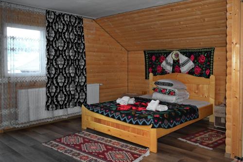 a bedroom with a bed in a wooden room at Casa Vladicu in Breb
