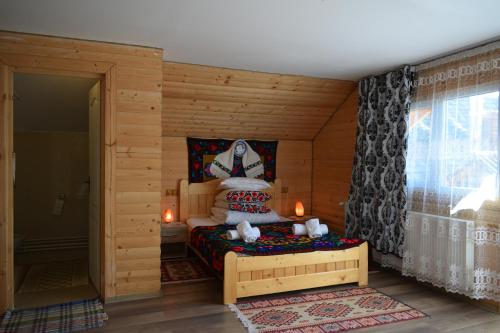 a bedroom with a bed in a wooden room at Casa Vladicu in Breb